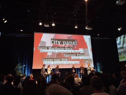 a picture of the main room of the conference. a big stage with a project above it, in front the audience sitting