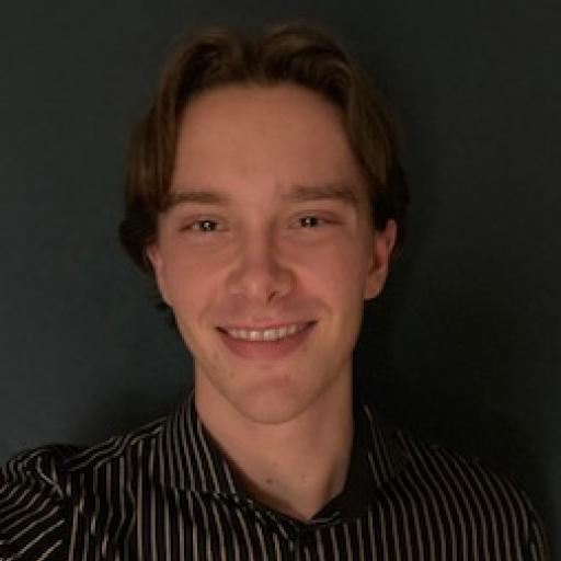 A picture of Pepijn. A man in front of a dark grey background, smiling with brown hair