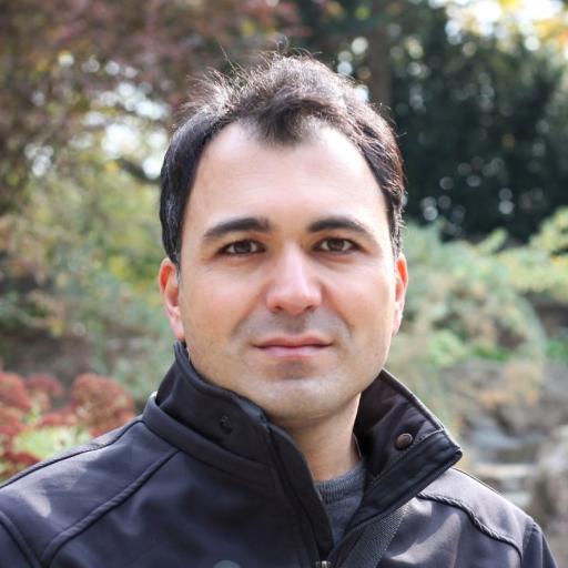 A picture of dr. Saleh Roshani, a man with dark hair wearing a dark jacket, standing in a nature background