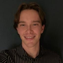 A picture of Pepijn. A man in front of a dark grey background, smiling with brown hair